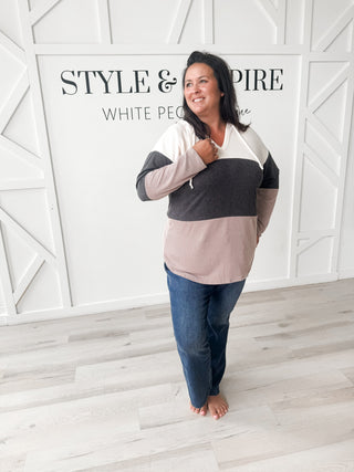 Woman wearing a color-blocked sweater and jeans