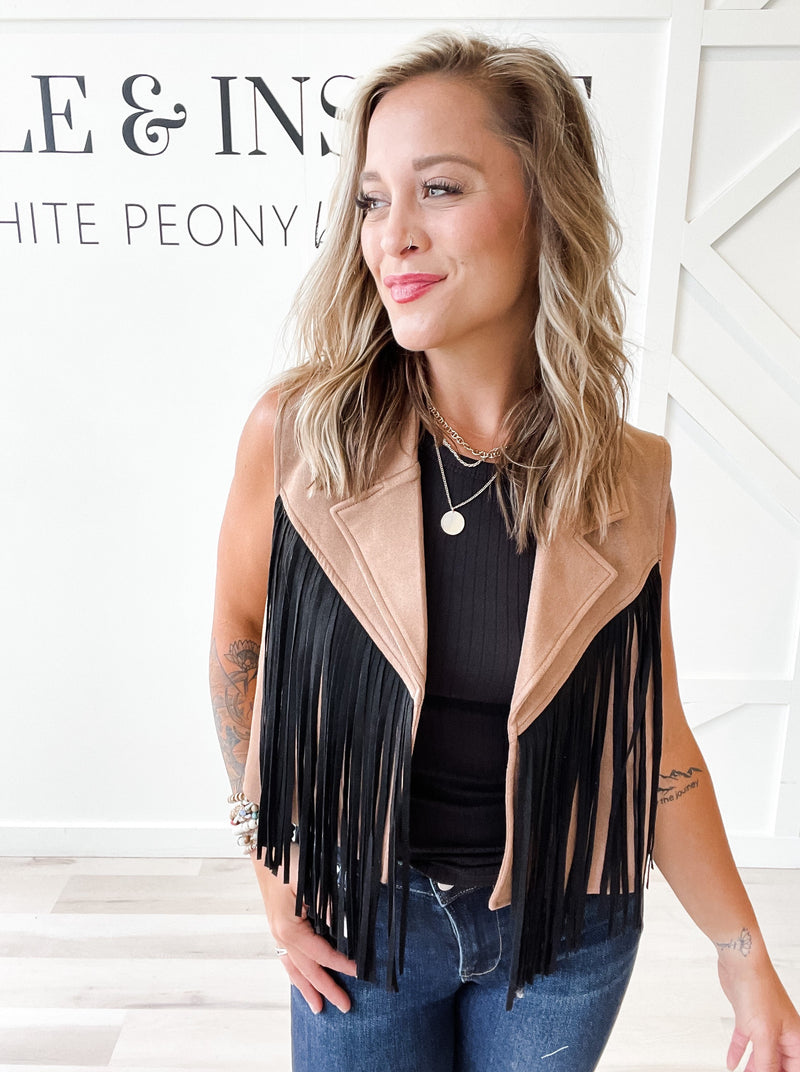 Fit: Brown colored vest. Shirt collar. Open front. Black fringe on the front and back. Cropped.