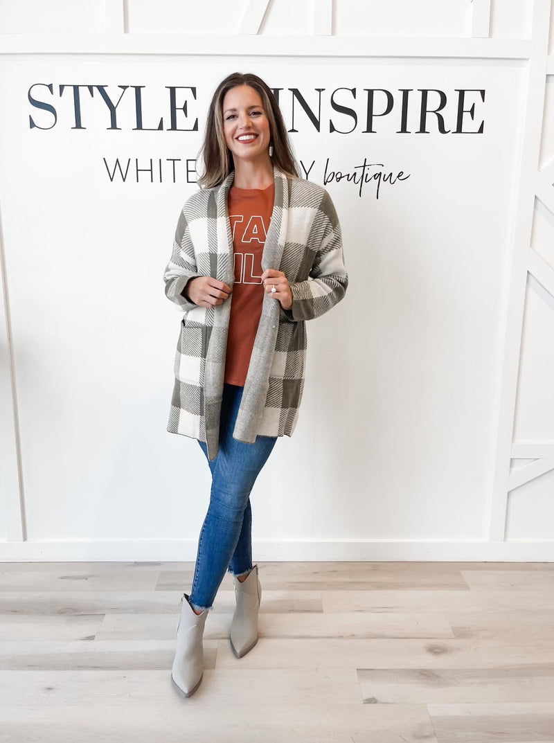 Fit: Shawl collar. Long line open front. Long sleeves. Patch pockets.  Style: The Clarice Shawl Collar Long Cardigan adds sophistication to any wardrobe with its bold gingham pattern and cozy long line cut. It features an open front, while its hem is finished clean for a stylish and dignified look. Enjoy the warmth and timeless style of this timeless piece.
