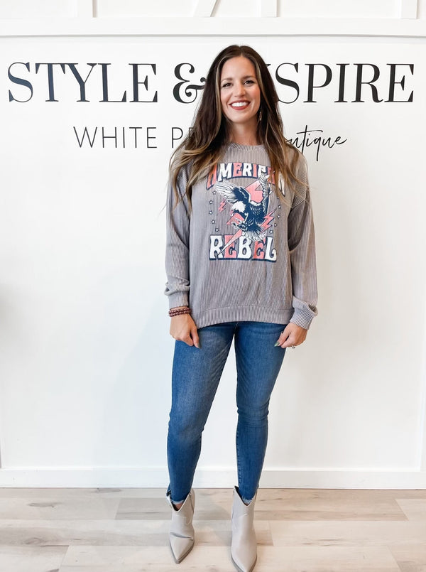 Crew neck. Drop shoulders. Long sleeves. Soft Ribbed fabric. Grey sweatshirt with American Rebel across the front in red and white letters