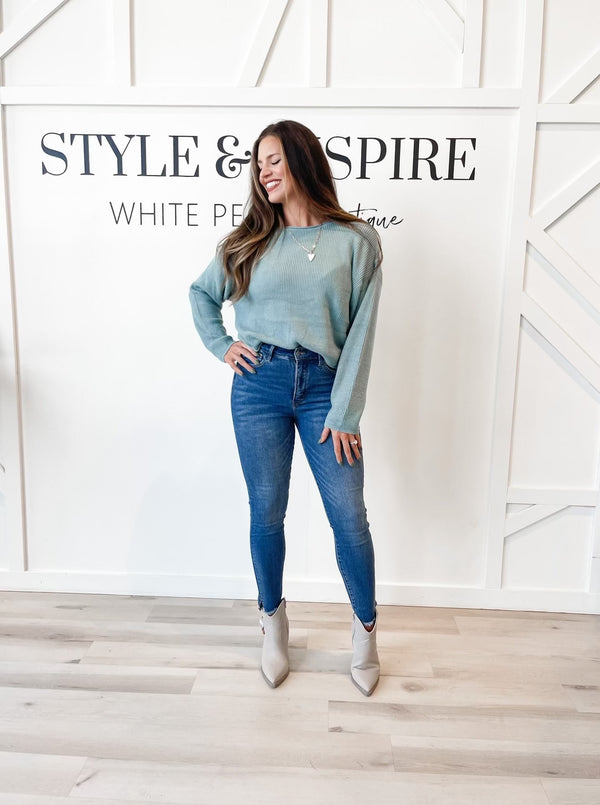 Fit: Round neckline. Drop shoulders. Ribbed texture. Delicate rolled neck and hem.  Style: Stay warm and stylish this season with Brynn Relaxed Crop Sweater. It features a delicate rolled neckline and hem, along with ribbed texture for a timeless look. Aqua in color