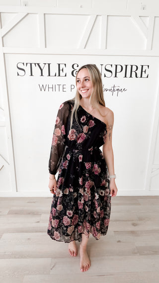 Woman wearing an off the shoulder pink and black floral dress