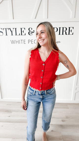 Woman wearing a red sleeveless button down vest