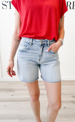 Woman wearing light wash long jean shorts 