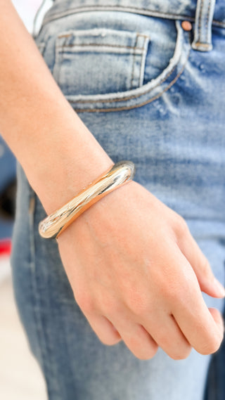 Woman wearing a gold chunky bangle bracelet