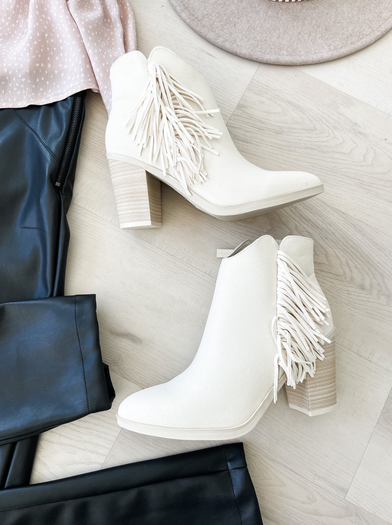 Fringe trim adds dimension to a block-heel bootie that's a modern take on Western style. Ivory color. 4 inch heal
